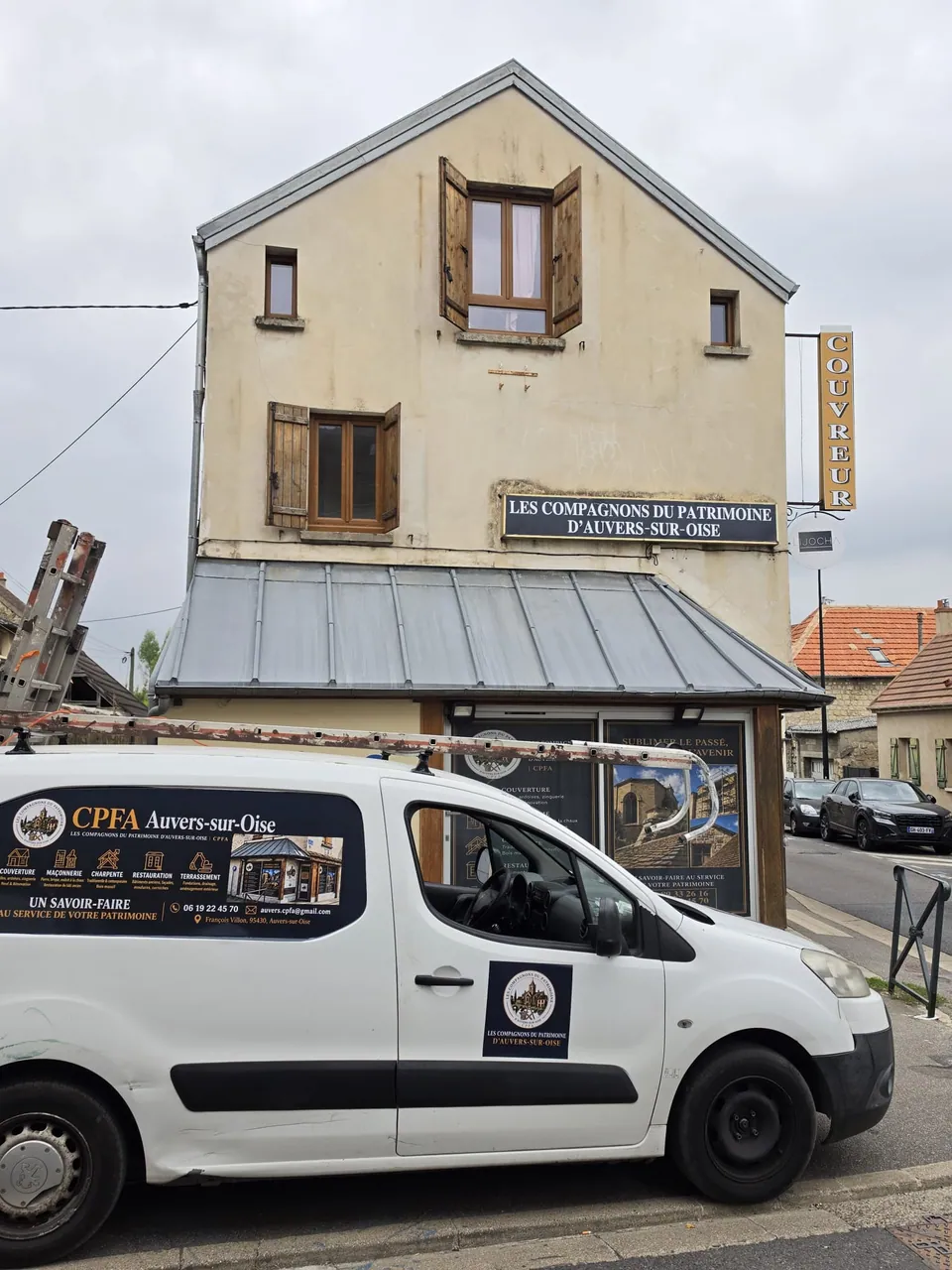 Façade portant l’enseigne des Compagnons du Patrimoine d’Auvers-sur-Oise et véhicule de l’entreprise